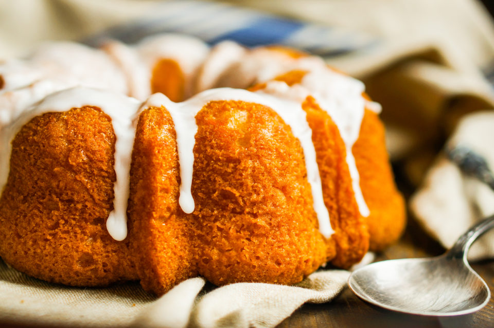 Bundt cake with white glaze on rustic background