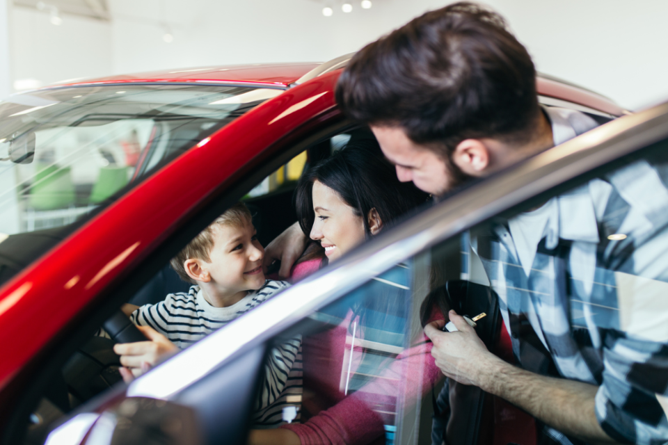 Family checking out a new car at the dealership