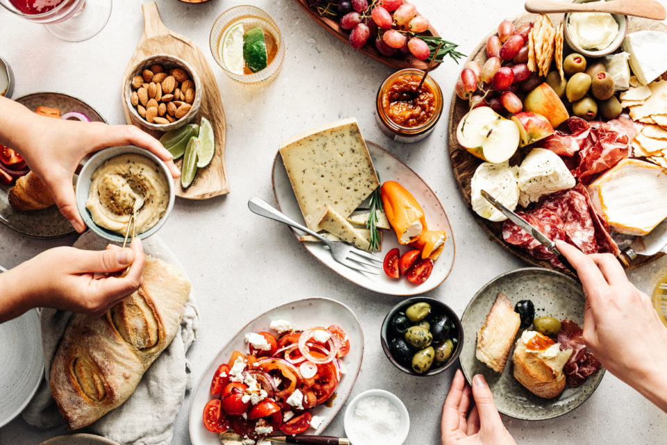 Women eating fresh Mediterranean platter on table