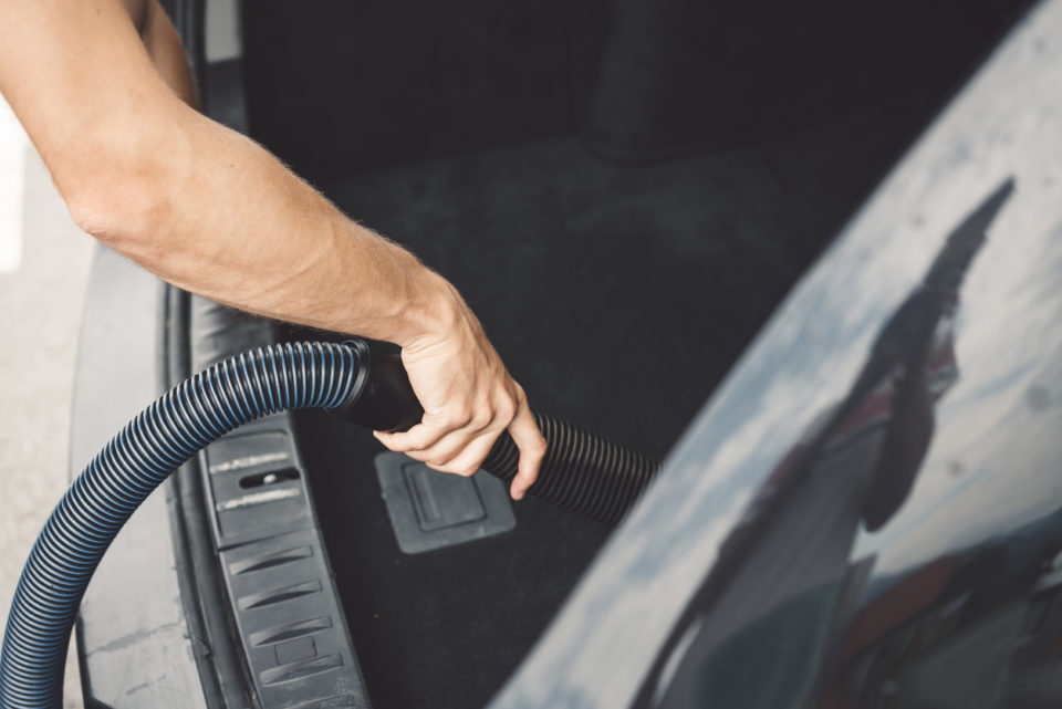 Man is vacuuming the inside of his car