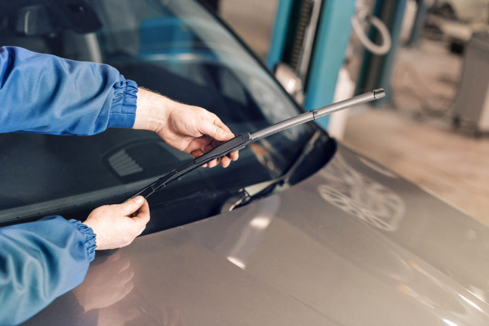 Technician changing windshield wipers on a car