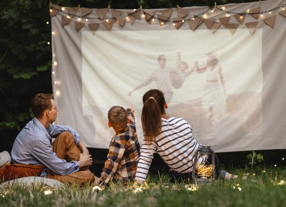 Family watching film in garden