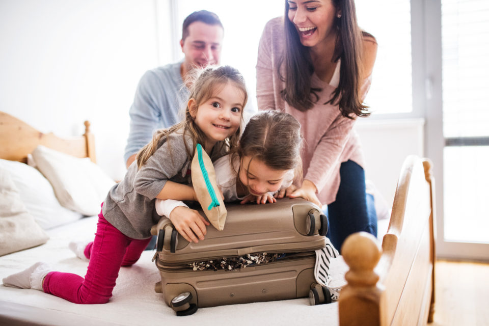 Young family with two children packing for holiday.