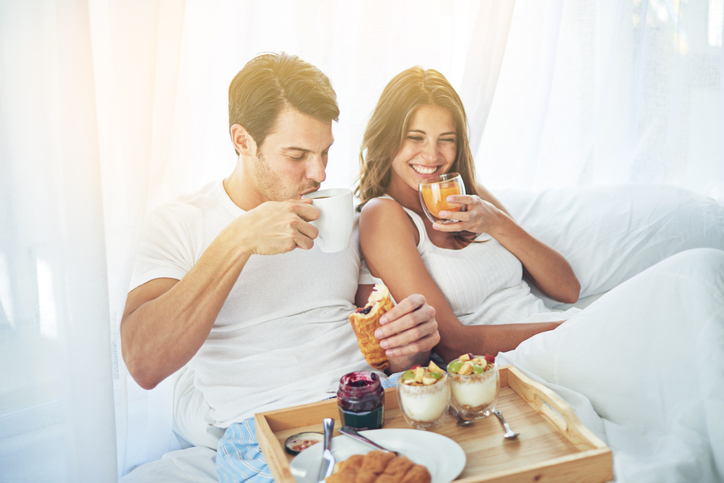 Shot of a loving young couple enjoying breakfast in bed