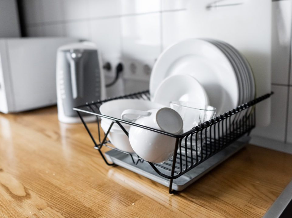 Dish rack with dishes inside, on kitchen counter